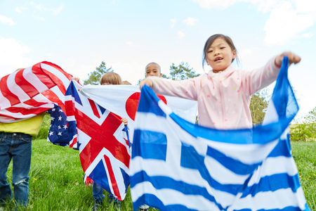 Children show national flags as a symbol of diversity and international understandingの写真素材