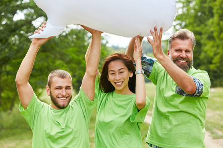 Three activists hold a white balloon together in nature