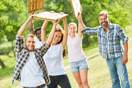 Young team doing fitness training or a teambuilding game with wooden tilesの写真素材