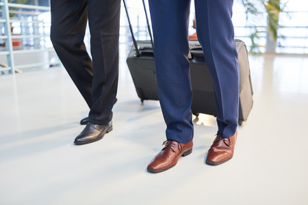 Two businessmen traveling with suitcases and in elegant leather shoesの写真素材