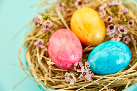 Three colorful easter eggs in the nest as easter background decoration