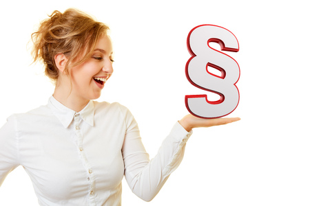 Laughing young woman with a big paragraph sign on her hand as a law conceptの写真素材