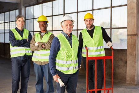 Four colleagues as a logistics team in the warehouse of an international freight forwarder