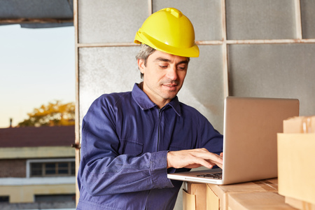 Logistics worker in online trade at laptop computer in logistics center