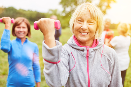 Group of seniors doing dumbbell training in physiotherapy in natureの写真素材