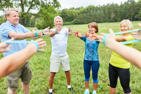 Group of active seniors exercises with the gym band in a rehab classの写真素材