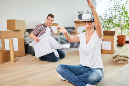 Young woman with VR glasses at the interior design in the new house after the move