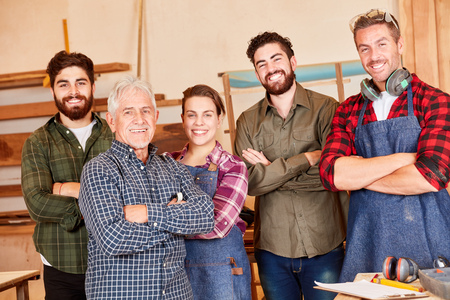 Self-assured artisan team with masters and trainees in the joineryの写真素材