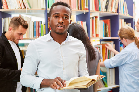 Young African man in the library with a book before the immigration test