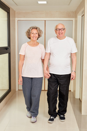 Senior couple holding hands at retirement home or rehab clinicの写真素材