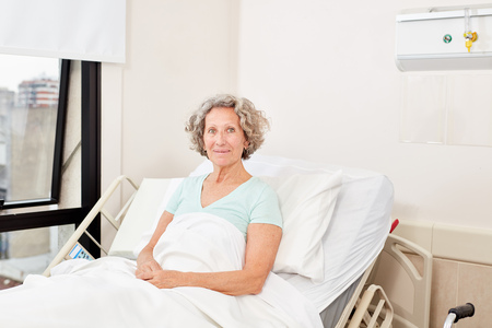 Senior woman as patient in hospital bed in hospital or rehab clinicの写真素材