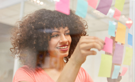 Creative African business woman brainstorming with colorful sticky notesの写真素材