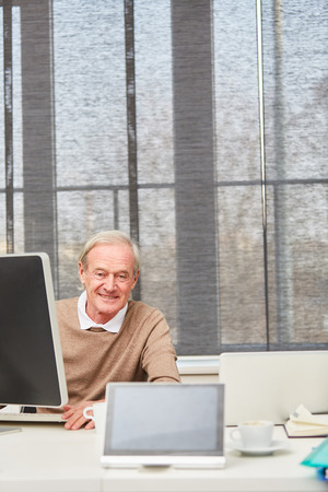 Senior businessman at his office working with computer の写真素材