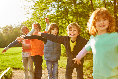 Children in international kindergarten or summer camp while balancing in the parkの写真素材