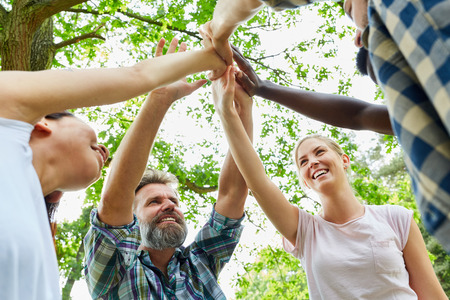 Young people make high five as a sign of teambuilding and support