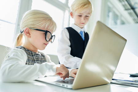 Boy and girl as business team work together on laptop computerの写真素材