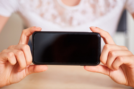 Female hands show the blank screen from a smartphoneの写真素材