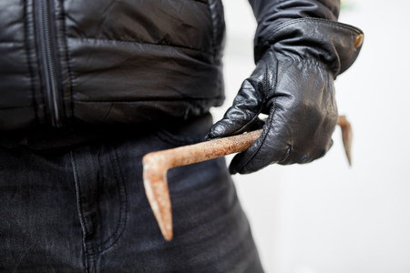Hand of burglar with crowbar or crowbarの写真素材