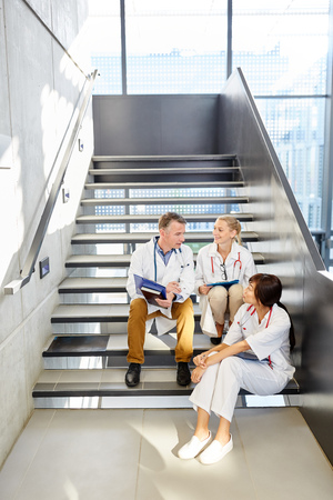 Doctor and nurses at the small talk in the staircase of the university clinicの写真素材