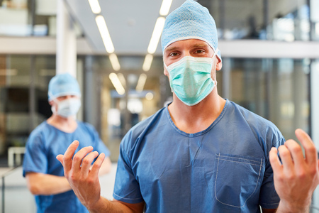 Man as a surgeon with competence in blue surgical clothing in the intensive care unit of the clinicの写真素材
