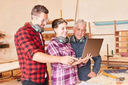 Artisan team with apprentice at laptop computer while designing a website