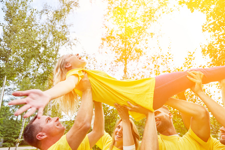 Group carries woman at teambuilding event as a sign of trust and cohesionの写真素材