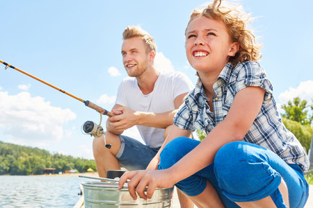 Boy fishing with his father on the lake at the weekend for relaxationの写真素材