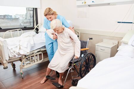 Nurse helps elderly woman with disability in a wheelchair in nursing homeの写真素材