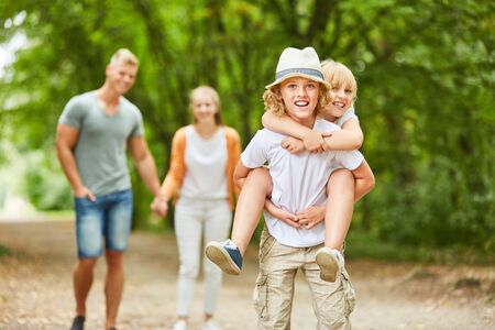 Boy is wearing piggyback on a walk in natureの写真素材