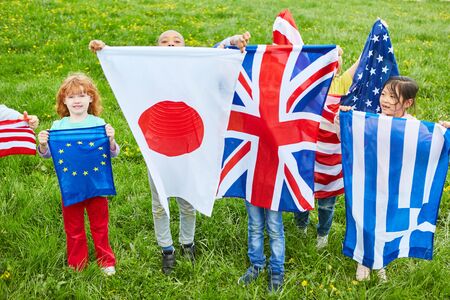 Children in international kindergarten with national flags as a symbol of diversityの写真素材