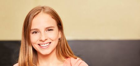 Young smiling woman as a teacher in front of a blackboard in the green owl