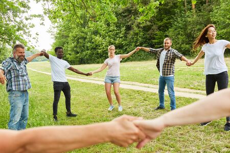 Young happy team forms a circle in the park in a teambuilding workshopの写真素材