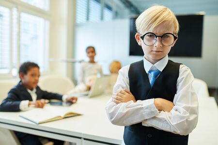 Boy as a critical manager or entrepreneur with arms crossed in a meetingの写真素材