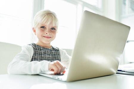 Smiling girl as typist or businesswoman at laptop computer