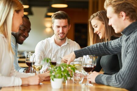 Young people having a glass of wine together in a bistro or restaurant