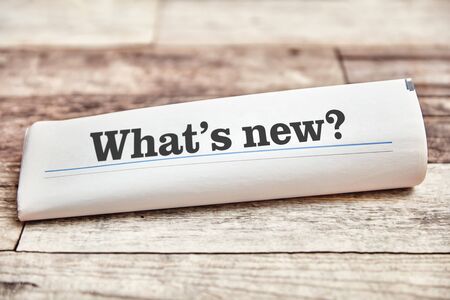 What's new as the title of a folded newspaper on a wooden tableの写真素材