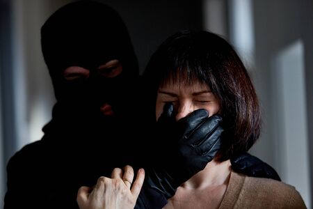 Robber threatens wife in robbery at homeの写真素材