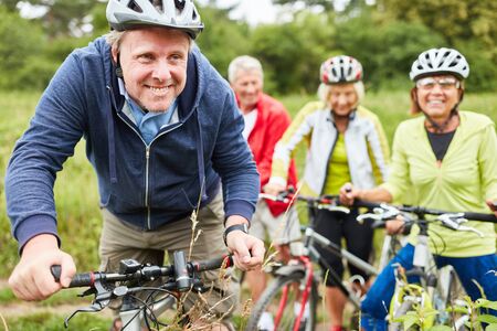 Sporty group of seniors together while cycling on vacation in nature