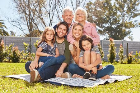 Happy big family with three generations together in the summer in the garden