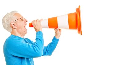 Senior man yells loudly in pylon as megaphone with angerの写真素材