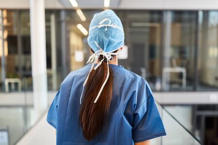 Surgeon in blue surgical gown on the way to the emergency room of the clinicの写真素材