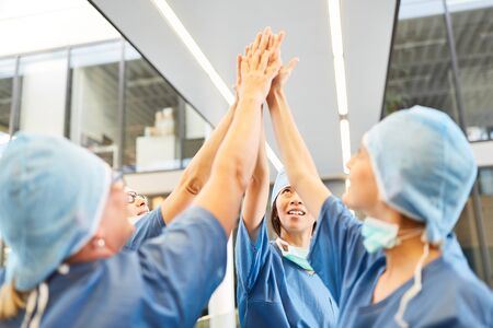 Team surgeons give themselves a high five as a sign of motivation and team spiritの写真素材