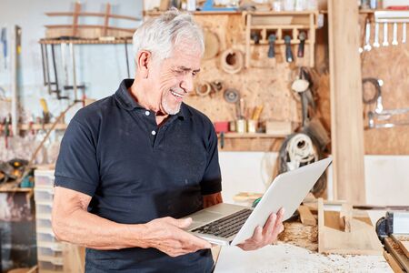Craftsman Master Using Laptop Computer is pleased about an order on the internetの写真素材