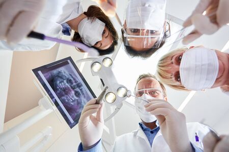 Medical team in the dental clinic of maxillofacial surgery in protective clothing with various instrumentsの写真素材