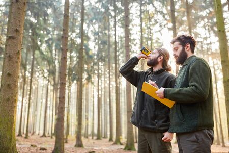 Forester determine tree height by three-point measurement with rangefinder in the forestの写真素材