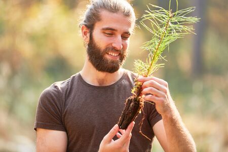 Young ranger looks forward to planting pine seedling during reforestation