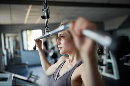Young woman in back training for the latissimus muscle at the train stationの写真素材