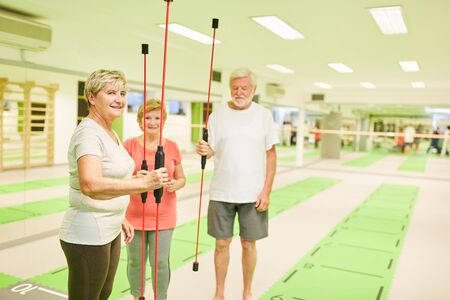 Senior group in fitness center with vibrating bar for deep muscle trainingの写真素材