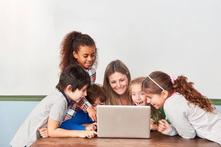 Kids and teacher have fun with the social media in computer lessonsの写真素材