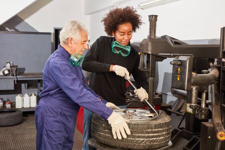 African woman as a mechanic apprentice and car master while hooping